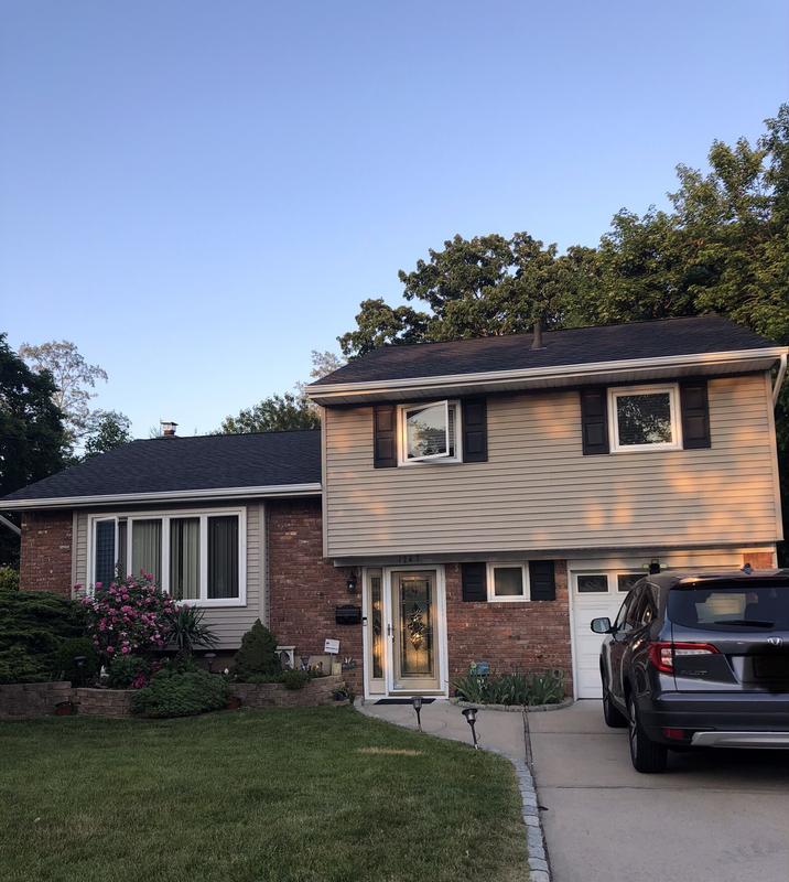 A house with a car parked in front, representing residential roofing services in New Jersey.