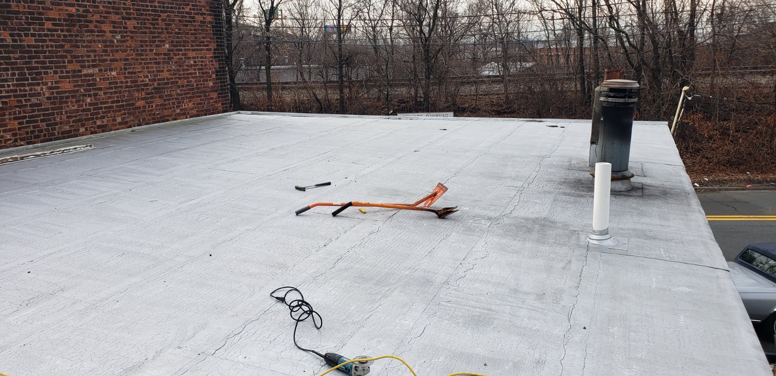 A roof featuring a metal pole and a ladder, indicative of ongoing roof installation work in New Jersey.