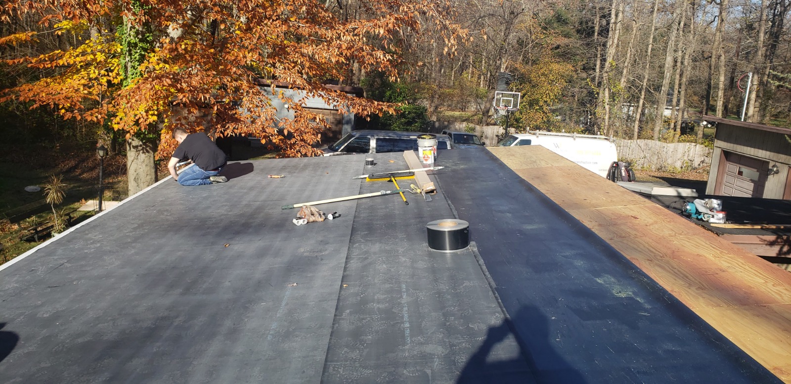 A flat roof with a ladder positioned on top, indicating ongoing roof installation or maintenance work in New Jersey.