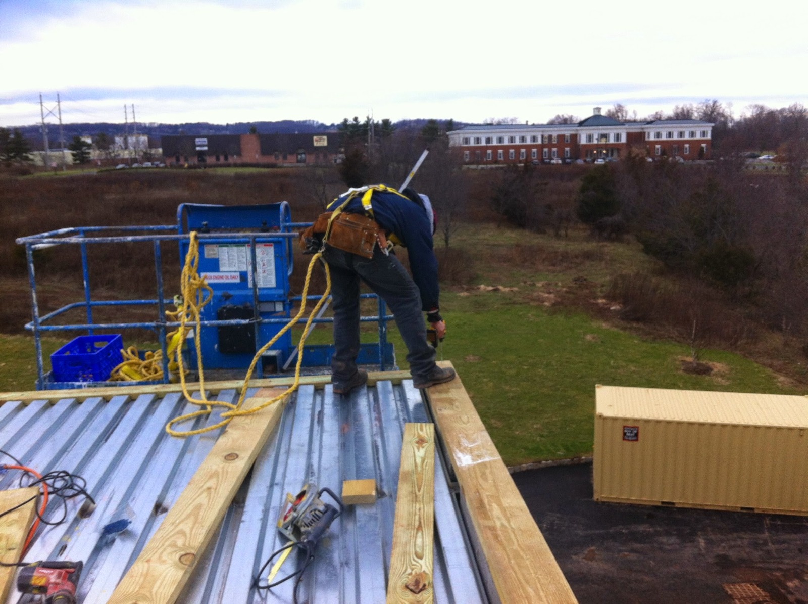 A man working on a metal roof, demonstrating professional roof installation in New Jersey.